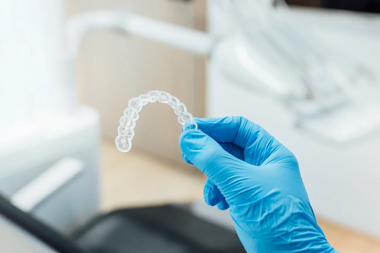 Clear retainer held in a gloved hand